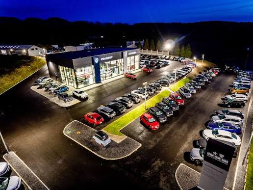 Multi-franchise dealership built by Kevin Egan, lit up at night.